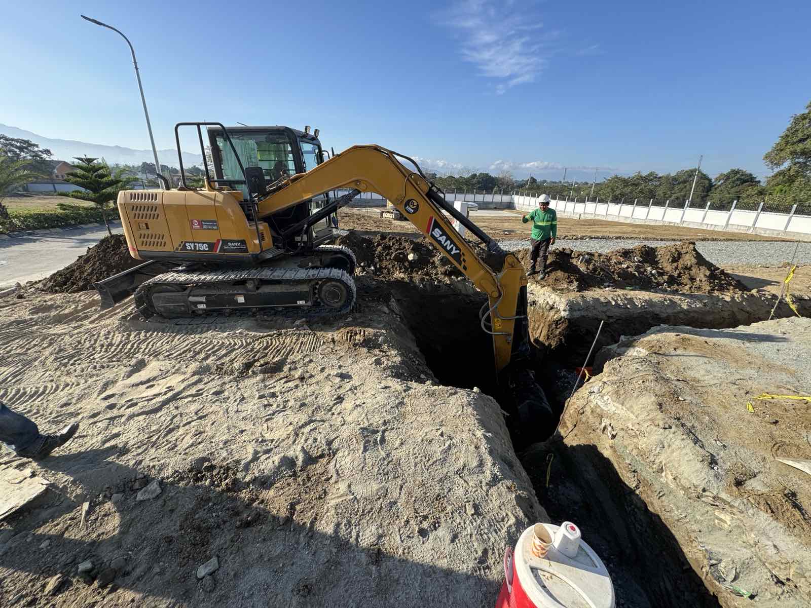 Watts Inc. construction crew operating an excavator on site
